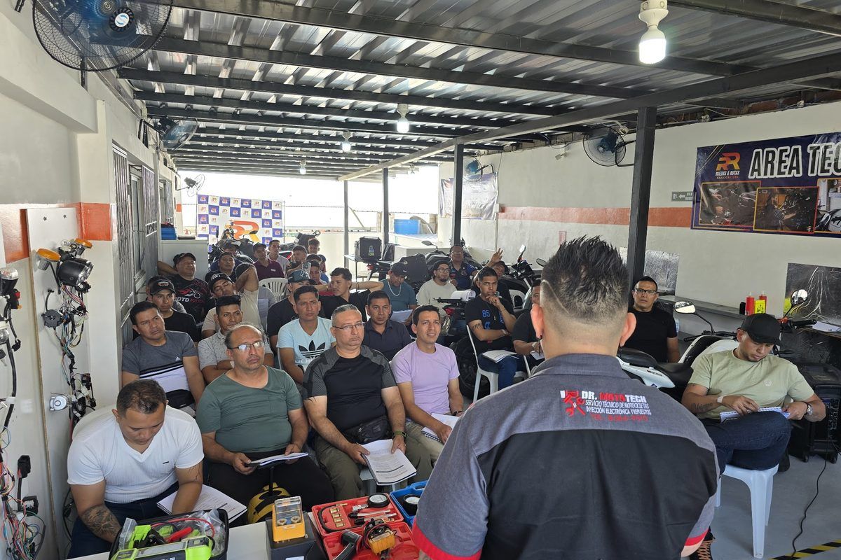 Huberth dando clase frente a un salón lleno de técnicos