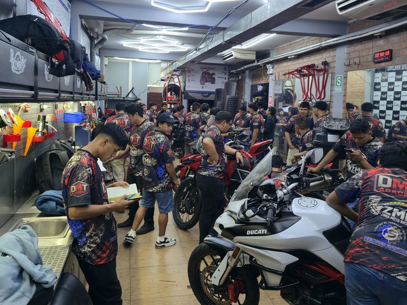 Alumnos practicando en el taller junto a una Ducati