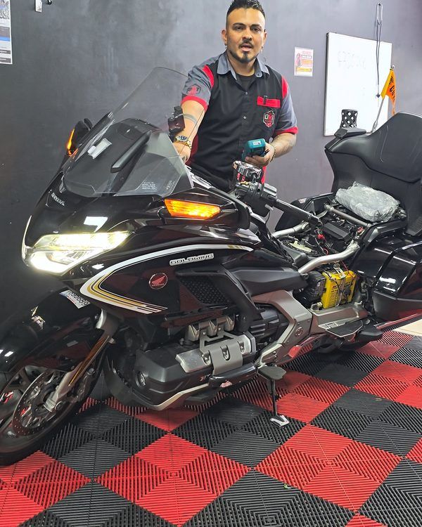 Huberth junto a una Honda Gold Wing en el taller